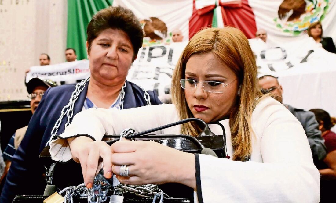 En medio de rechiflas y mantas a favor y en contra de la reforma, las diputadas locales panistas María del Carmen Ponton y Ana Ledesma se encadenaron a la tribuna para evitar la aprobación del dictamen (PATRICIA MORALES. EL UNIVERSAL)