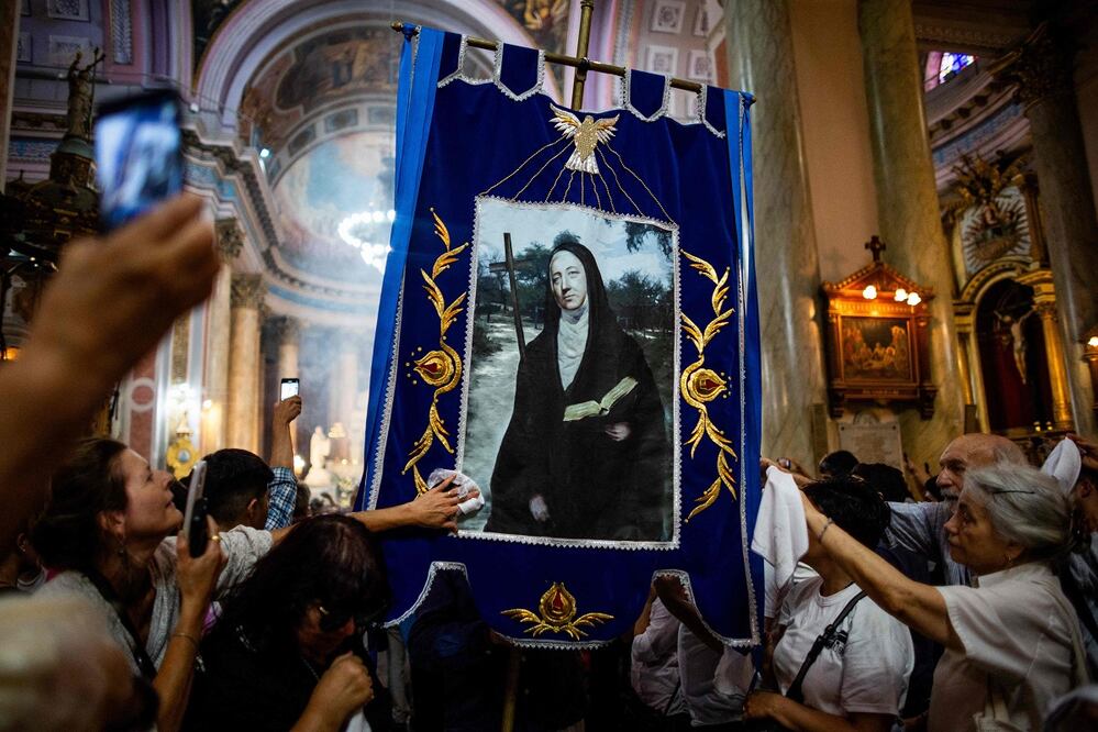 La gente toca una imagen de María Antonia de Paz y Figueroa, conocida como Mama Antula, el día de su canonización, en la Basílica de Nuestra Señora de la Merced de Buenos Aires, Argentina, el 11 de febrero de 2024. FOTO: TOMAS CUESTA. AFP