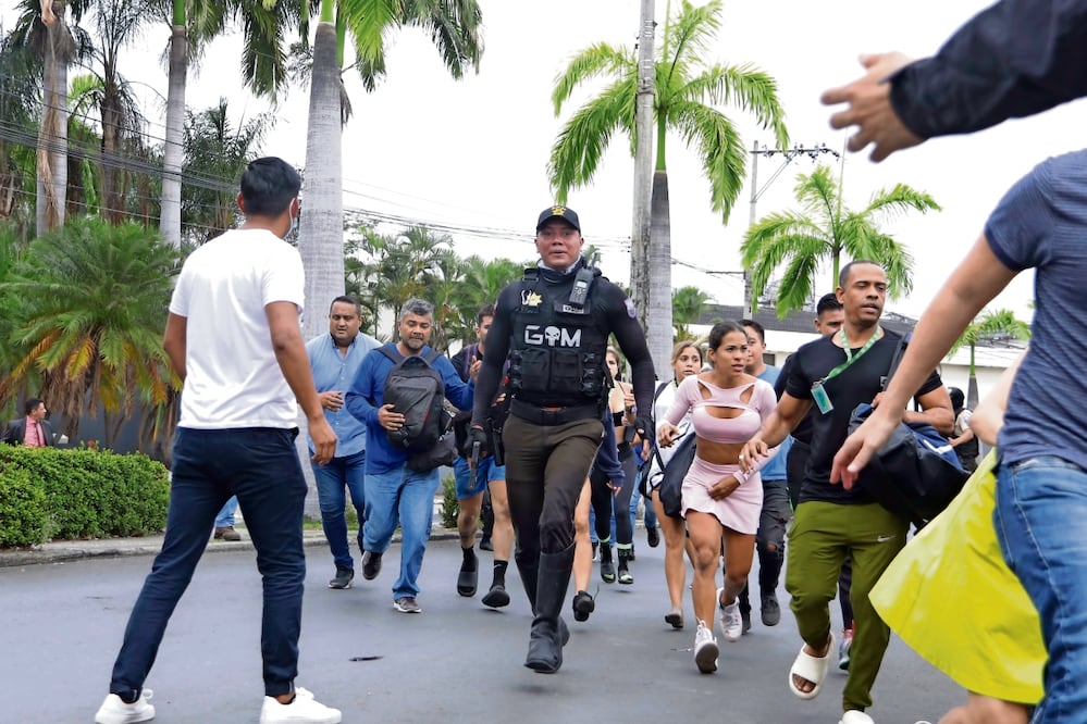Personal del canal TC Televisión, tras ser evacuados después de que un grupo armado irrumpiera en la estación en Guayaquil. Foto: Cesar munoz | AP