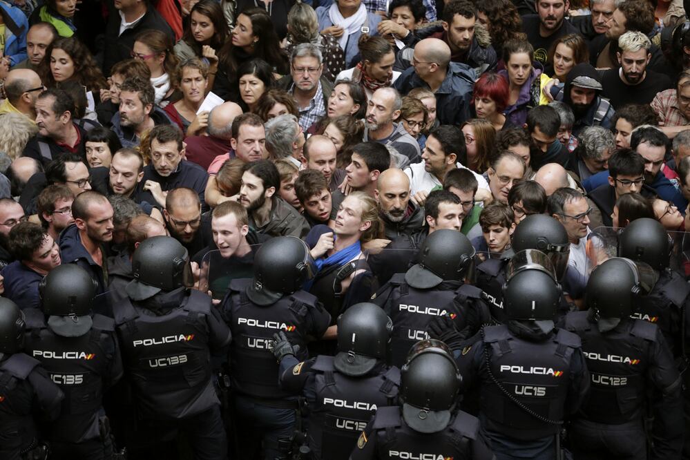 Agentes antidisturbios de la Policía Nacional forman un cordón de seguridad en los alrededores del colegio Ramón Llull de Barcelona. (EFE)