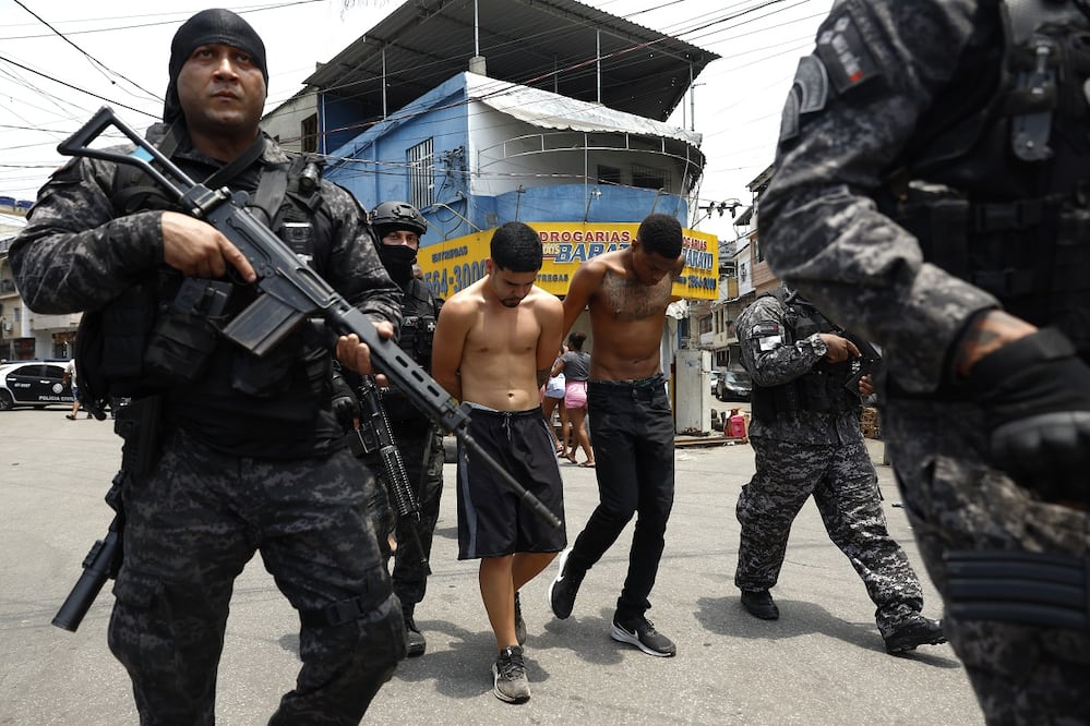 Integrantes de la Policía de Río de Janeiro trasladan a un grupo de personas durante un operativo contra el Comando Vermelho, en Río de Janeiro, Brasil. FOTO: ANTONIO LACERDA. EFE