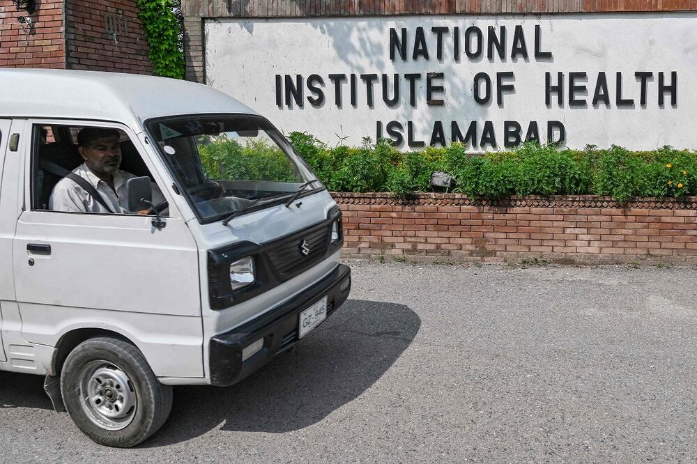Un hombre que viaja en un vehículo pasa por el edificio del Instituto Nacional de Salud (NIH), un instituto de investigación paquistaní principalmente responsable de investigaciones biomédicas y relacionadas con la salud, en Islamabad. Foto: AFP
