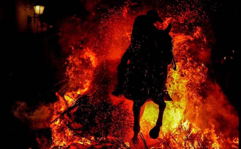 Un hombre cabalga sobre una hoguera como parte de un ritual en honor a San Antonio Abad, el santo patrón de los animales domésticos, en San Bartolomé de Pinares, España. Foto: AP