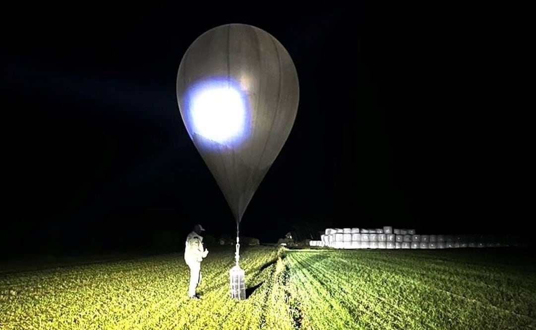 En esta imagen sin fecha proporcionada por la Guardia Estatal de Fronteras, un agente inspecciona un globo utilizado para llevar cigarrillos a Lituania, un sistema utilizado a menudo por contrabandistas bielorrusos para llevar el contrabando al país de la Unión Europea. Foto: AP/Archivo