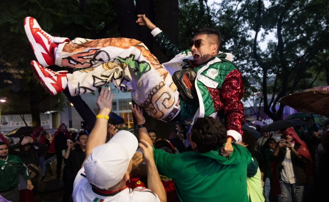 Bajo la lluvia, algunos aficionados de la selección mexicana se reúnen en el Ángel de la Independencia a un día del México vs Ecuador. Foto Hugo Salvador El Universal