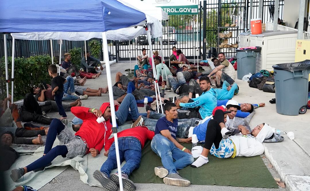 Migrantes recién llegados esperan en un garaje de la Oficina de Aduanas y Protección Fronteriza de Estados Unidos en Marathon. Foto: AP 