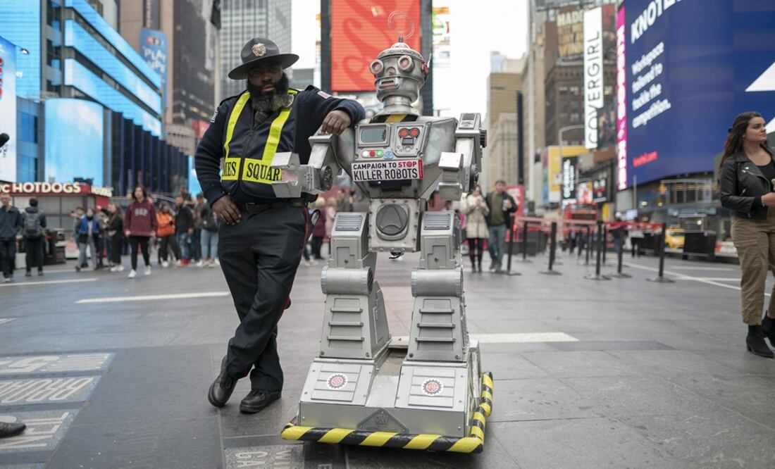 Un agente de seguridad posa junto a un robot el 20 de octubre en Times Square, Nueva York. Foto: /Campaign to Stop Killer Robots