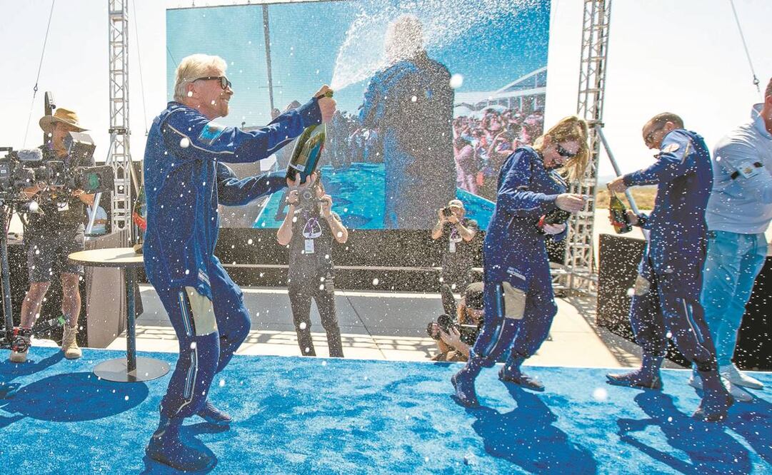 El multimillonario Richard Branson logró su apuesta. A su regreso a la Tierra, festejó con sus acompañantes con champán, en Nuevo México. Foto: Andres Leighton/AP.