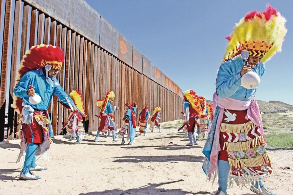 Bailarines tradicionales de México se presentaron ayer durante una misa para migrantes en la zona fronteriza de Ciudad Juárez, Chihuahua, y Estados Unidos. (HERIKA MARTINEZ. AFP)