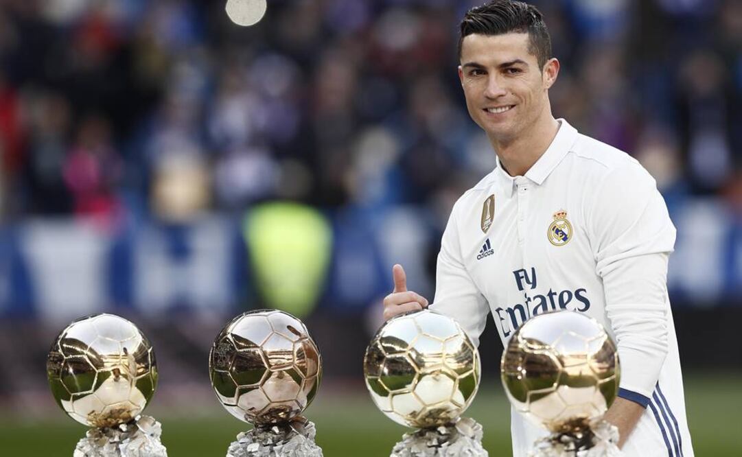 Cristiano Ronaldo posa en el Santiago Bernabéu con sus cuatro Balones de Oro. (Foto: EFE)