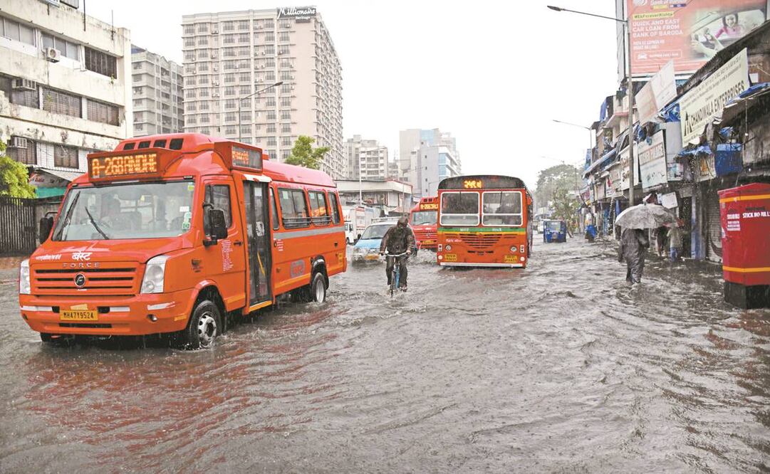 Los indios caminan por una calle inundada durante las fuertes lluvias, luego de que el ciclón Tauktae azotara Bombay. Foto: EFE