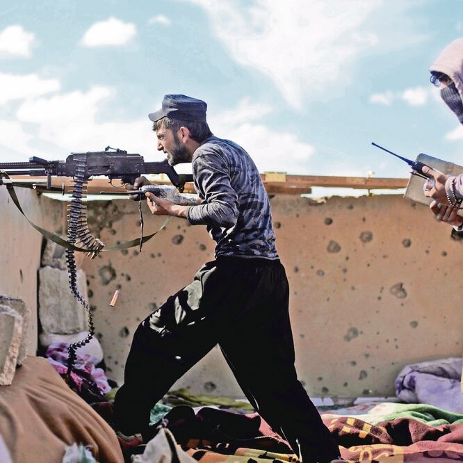 Un combatiente de las Fuerzas de Siria Democrática dispara con una ametralladora en Baghouz, en Siria. RODI SAID. REUTERS