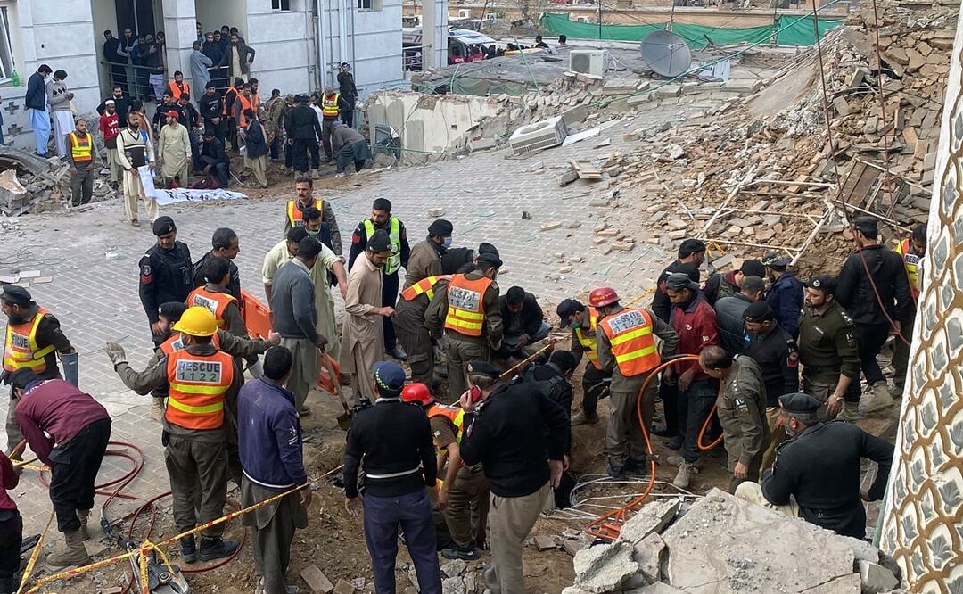 Funcionarios de seguridad y rescatistas buscan cuerpos en el lugar del atentado suicida, en Peshawar, Pakistán. Foto: AP