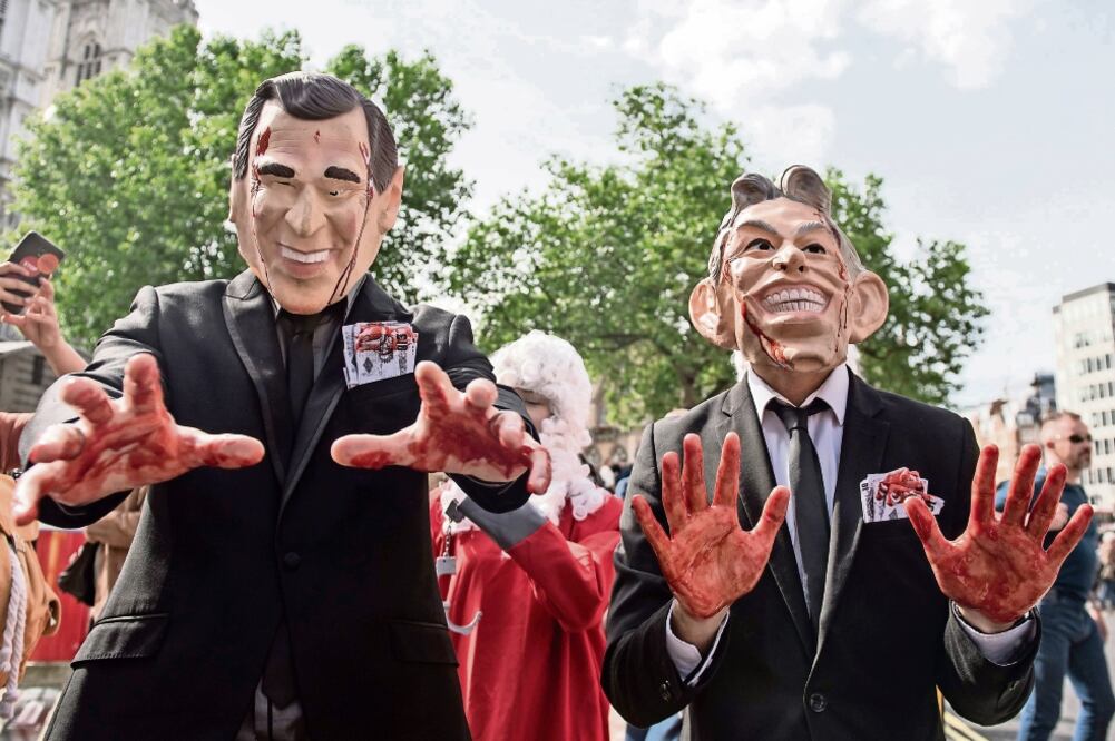 Manifestantes caracterizados como el ex presidente estadounidense George W. Bush (izq.) y ex primer ministro británico Tony Blair (der.), participan en una protesta en el centro de conferencias Queen Elizabeth II (WILL OLIVER. EFE)
