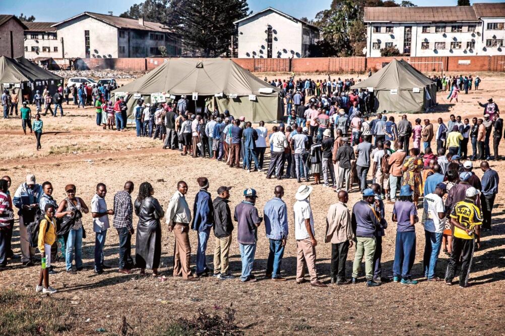 Decenas de personas hacen fila para votar en las elecciones presidenciales que tuvieron lugar ayer en Zimbabue. Foto: LUIS TATO. AFP