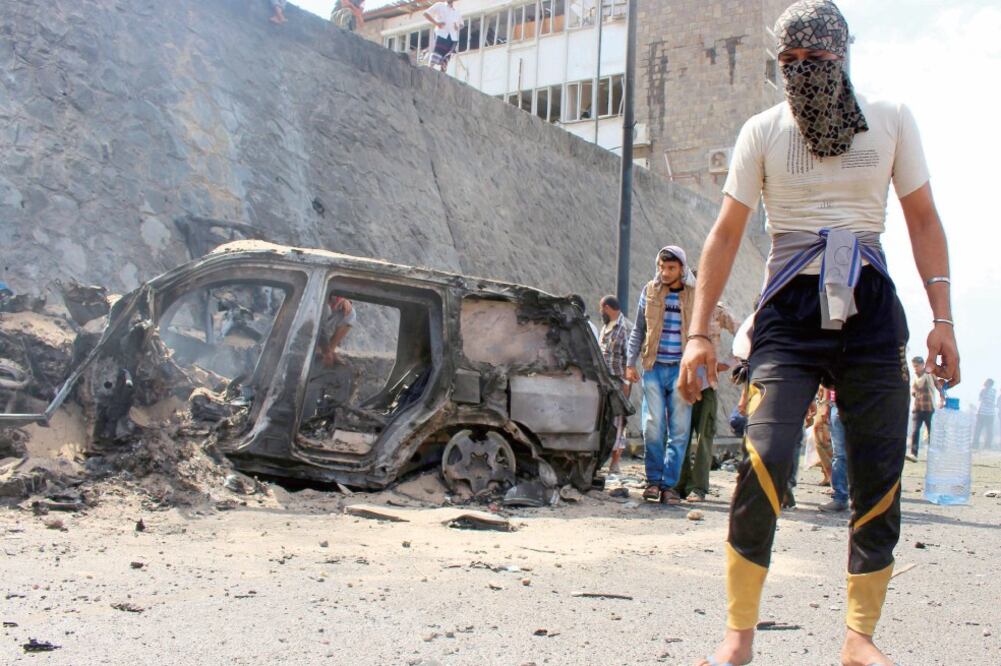 Yemeníes en el lugar donde el gobernador de Adén, Yafar Mohamed Saad, fue víctima de un atentado con coche-bomba. Él y cinco de sus guardaespaldas murieron (EFE)