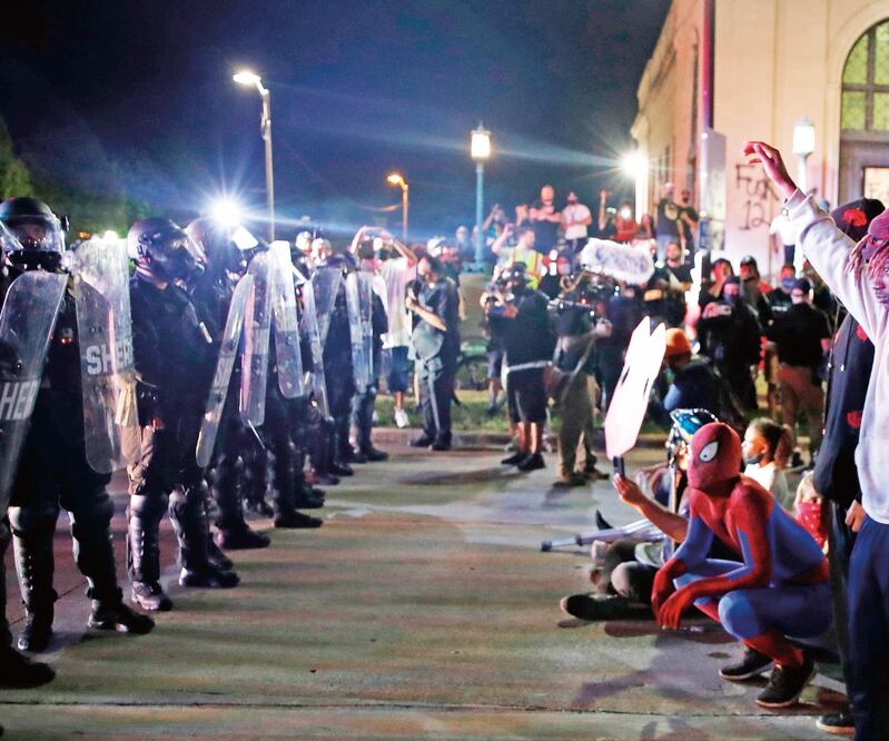 Jóvenes, durante una manifestación contra el racismo, enfrente de las fuerzas del orden, en Kenosha, Wisconsin. KAMIL KRZACZYNSKI. AFP