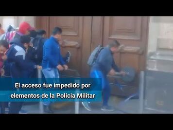 Nornalistas de Ayotzinapa dañan puerta de Palacio Nacional