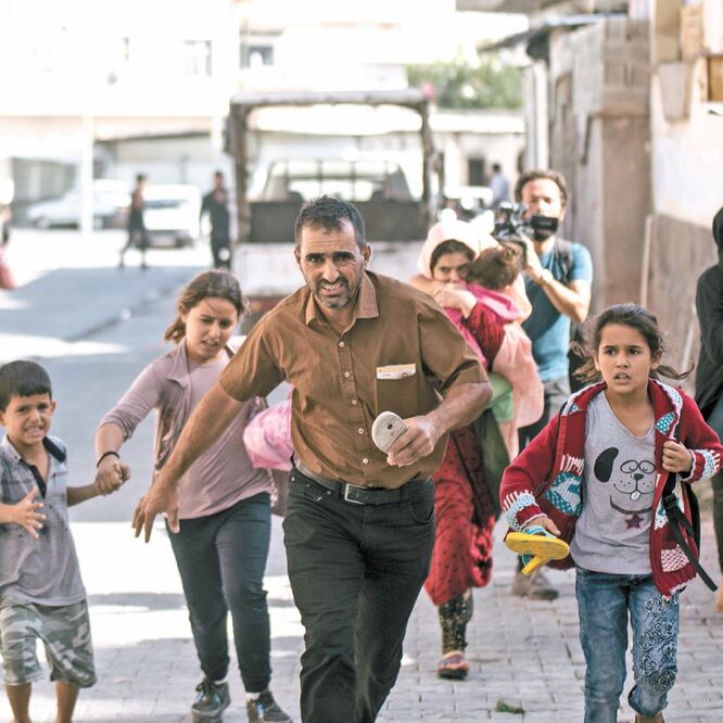 Personas corren a refugiarse después de que ayer dispararon morteros desde Siria, en Akcakale, Turquía. ISMAIL COSKUN. AP