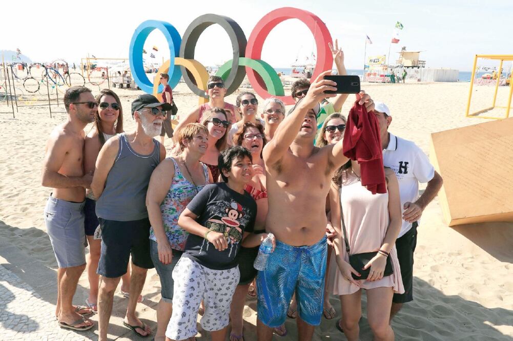 Visitantes en la playa de Copacabana se toman una foto cerca de la sede de los encuentros de volibol playero (BARBARA WALTON.EFE)