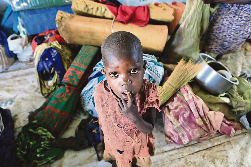 Un niño desplazado de Sudán del Sur permanece junto a las pertenencias de su familia después de viajar a través de la frontera con el norte de Ugandan (JAMES AKENA. REUTERS)