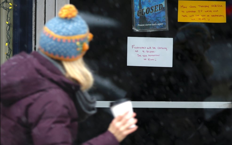 Una mujer pasa frente a un negocio que cerró debido a la tormenta de nieve en Portsmouth, New Hampshire, el martes 2 de diciembre de 2025. Foto AP