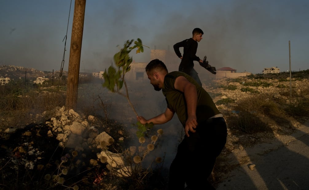 Palestinos sofocan un incendio tras una incursión de las fuerzas israelíes en la aldea de Sarra, cerca de Naplusa, donde se utilizaron gases lacrimógenos durante el operativo (25/07/2026). Foto: AP