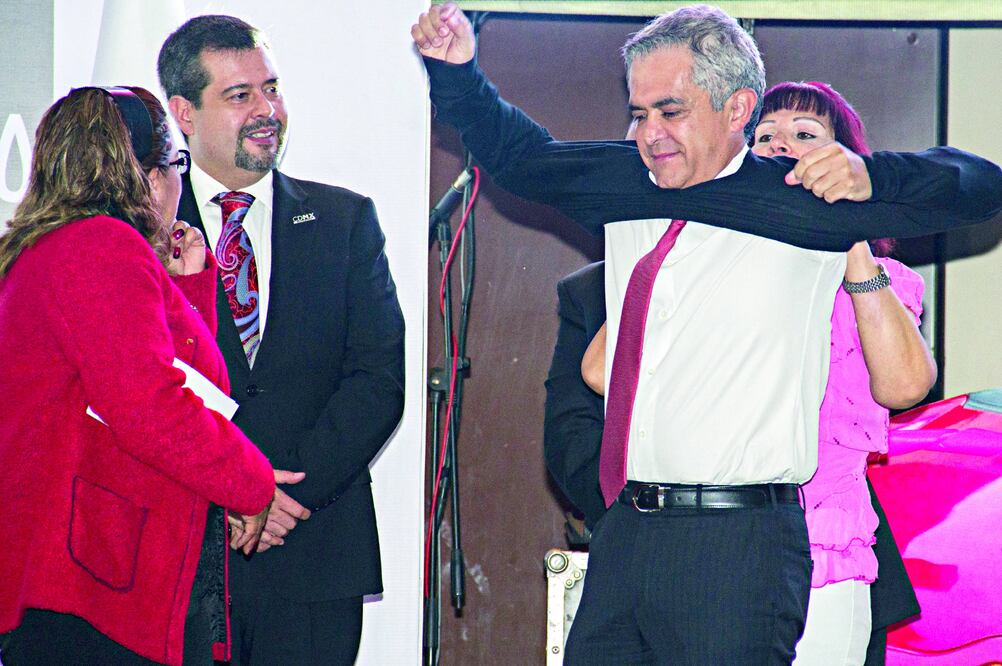 Al grito de "!que se lo ponga, que se lo ponga!", Mancera se despojó del saco y, entre piropos, se puso el suéter que le regalaron las trabajadoras (ESPECIAL)