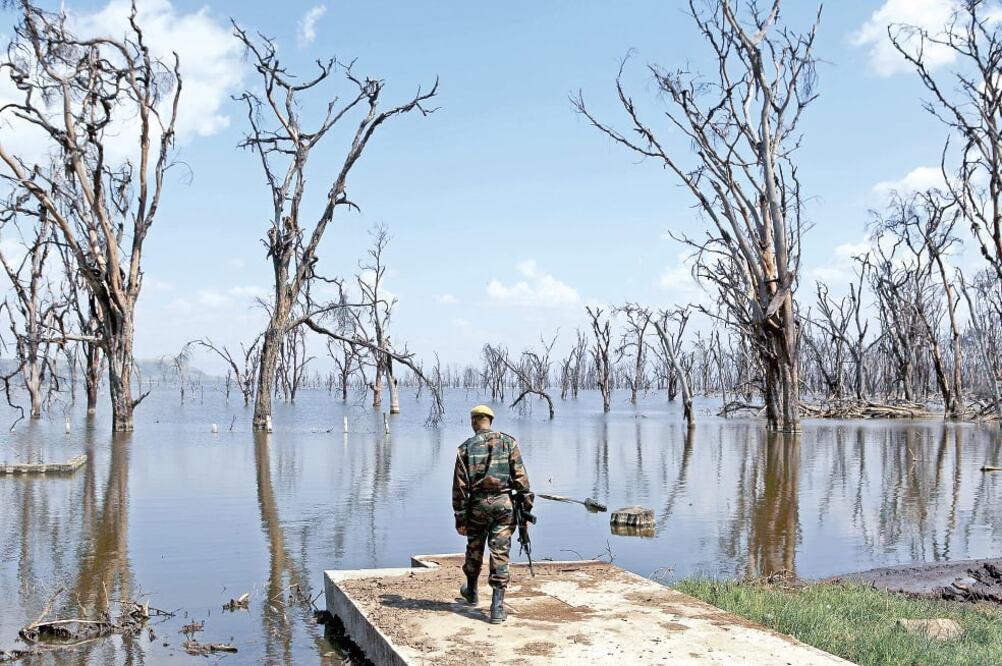 Un guardia forestal revisa los daños ocasionados por las inundaciones en el lago del Parque Nacional Nakuri, en Kenia, en agosto pasado. Activistas y ONG han denunciado los efectos del calentamiento global en éste y otros lugares (JOE PENNEY. REUTERS)