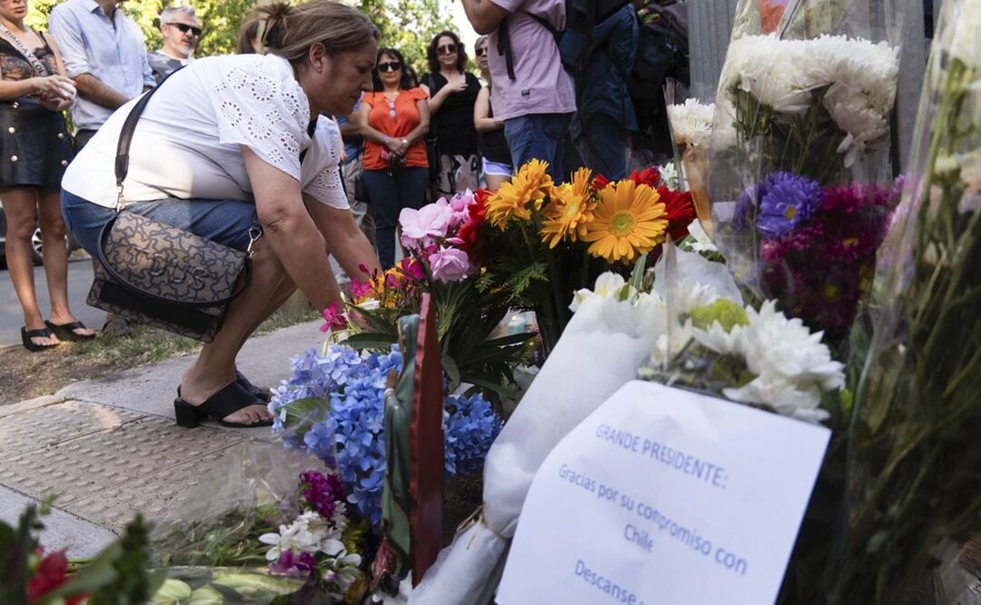 Personas dejan flores en la casa del fallecido expresidente chileno Santiago Piñera en Santiago, Chile. Foto: AP