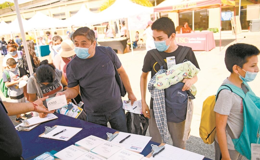 Las personas reciben cajas con mascarillas durante un evento de regreso a la escuela, en Los Ángeles. Foto: Patrick T. Fallon. AFP