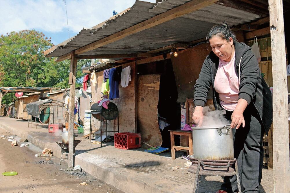 Una mujer prepara alimento en uno de los refugios instalados en la costanera de Asunción, a raíz de las inundaciones que afectaron a varias familias en los bañados sur y norte de la capital paraguaya (ANDRÉS CRISTALDO. EFE)