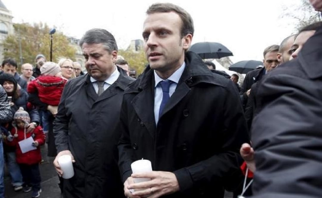 French Economy Minister Emmanuel Macron (R) and his German counterpart Sigmar Gabriel (L) hold candles at Place de la Republique a week after a series of deadly attacks in Paris. (Photo: Reuters)