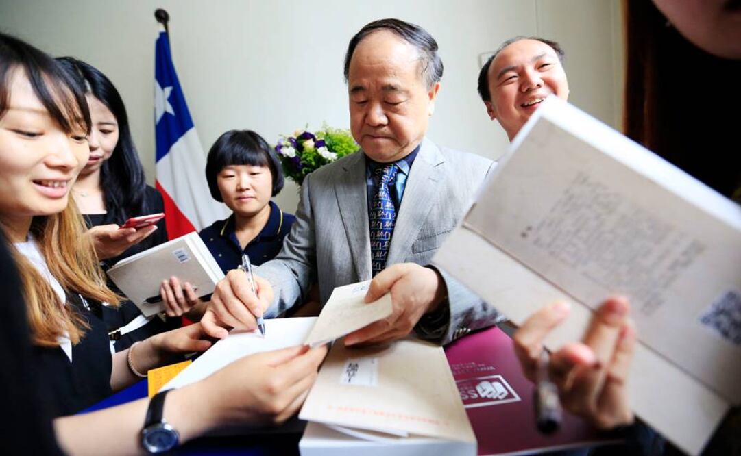 El Nobel firmando libros a sus lectores durante su estancia en la embajada de China en Santiago de Chile. (FOTO: EFE)