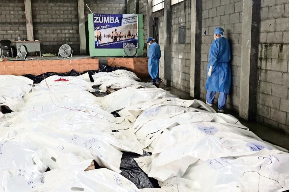 Los cuerpos envueltos en bolsas y mantenidos con ventiladores se acumularon ayer en una bodega de Escuintla, mientras los forenses los identifican. (SONIA PÉREZ. AP)