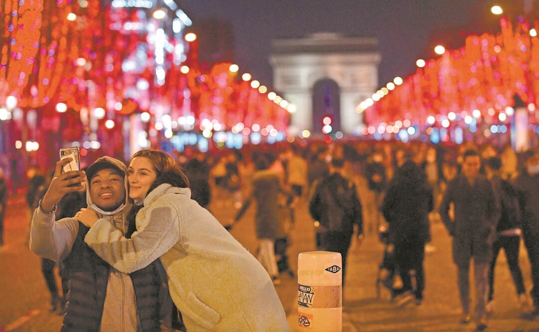 Una pareja en la avenida Campos Elíseos, en la víspera de Año Nuevo. Francia reportó ayer más de 270 mil casos de Covid-19 en un día. Foto: Archivo/ AFP