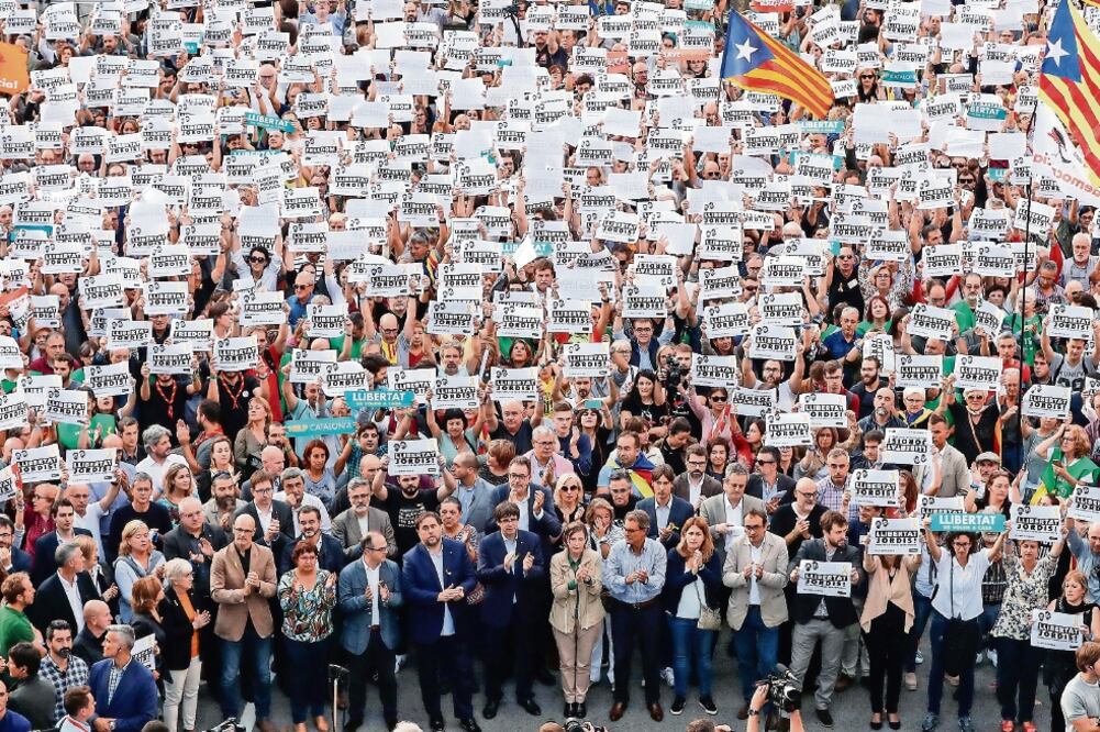 El presidente Carles Puigdemont (centro), y otros miembros de la administración participaron ayer en una marcha independentista celebrada en Barcelona. La manifestación fue por el ingreso en prisión de dos líderes secesionistas catalanes.(GONZALO FUENTES)