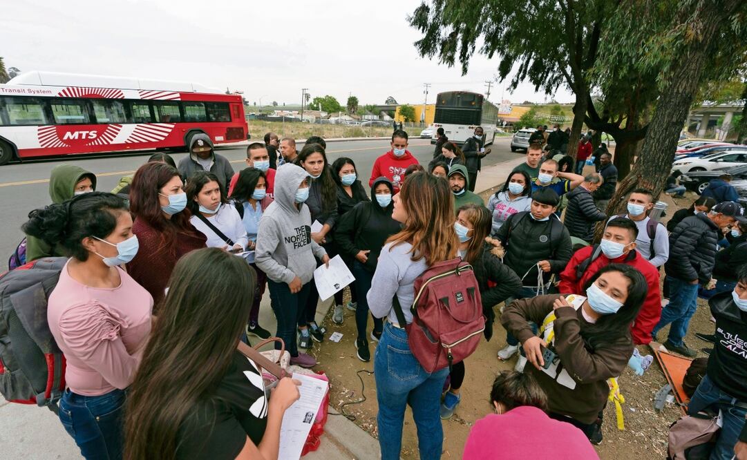 Migrantes en San Diego, California, escuchan a una voluntaria explicar lo que tendrán que hacer tras ser detenidos y solicitar asilo en EU. Foto: AP