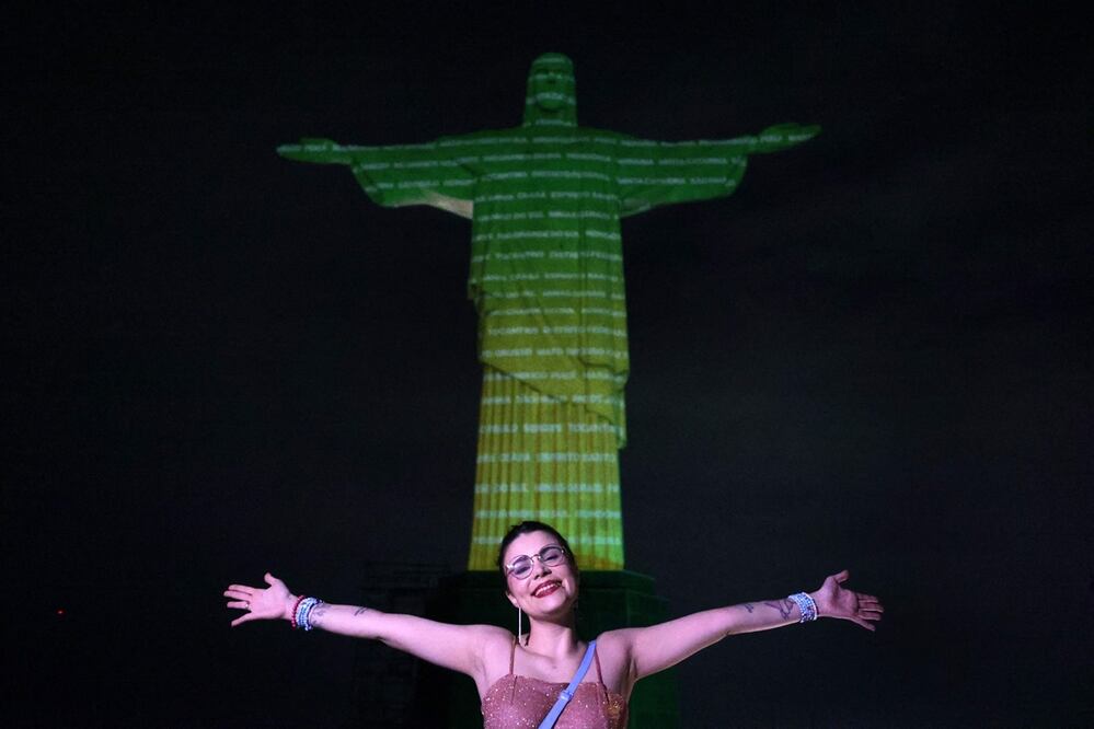 Un fan posa frente a la imagen proyectada sobre el Cristo Redentor para dar la bienvenida a la cantante estadounidense Taylor Swift en Río de Janeiro, Brasil, el 16 de noviembre de 2023. Foto: AFP