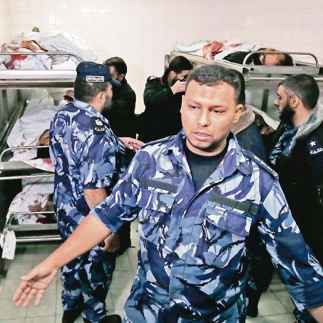 Agentes palestinos se reunieron en una morgue del hospital adonde llevaron los cuerpos de cinco de los seis hombres muertos en una operación israelí en Gaza. (SAID KHATIB. AFP)