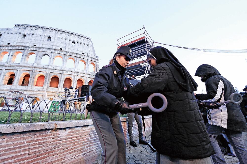 Una policía revisa a una monja con un detector de metales, previo al Viacrucis encabezado ayer por el papa Francisco, en el Coliseo (YARA NARDI)