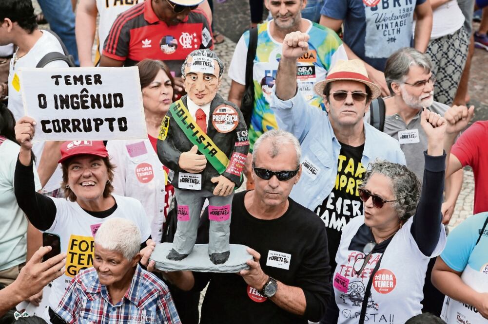 Brasileños protestaron ayer en Río de Janeiro contra el presidente Michel Temer. En el cartel de una manifestante se lee: “Temer, el ingenuo corrupto”. (JULIO GUIMARAES. REUTERS)
