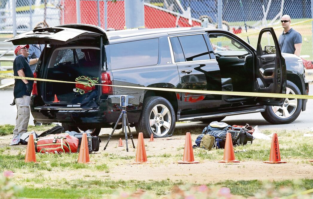 Inspectores del FBI revisan una camioneta con un agujero de bala en el parabrisas, tras el tiroteo de ayer en Alexandria, Virginia. (ALEX WONG. AFP)