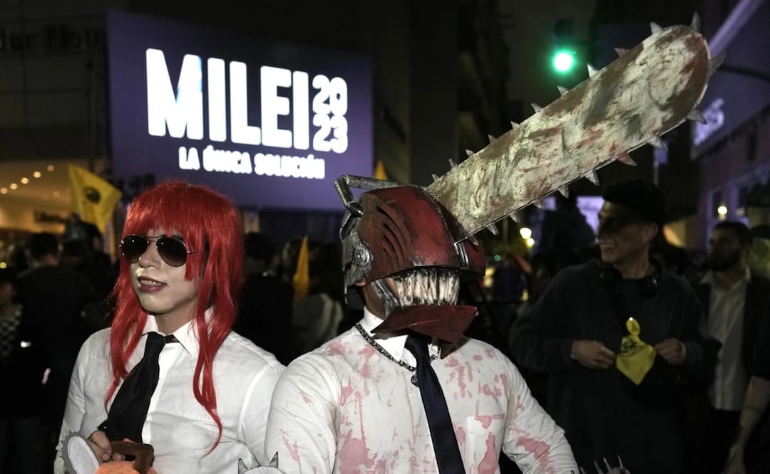 Seguidores del candidato a la presidencia de Argentina Javier Milei, disfrazados con motosierras, en el exterior de la sede de campaña del político tras el cierre de los centros de votación. Foto: AP