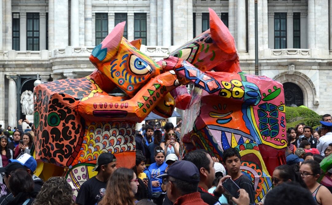 Two massive papier-mâché alebrijes entangled in front of the Palace of Fine Arts