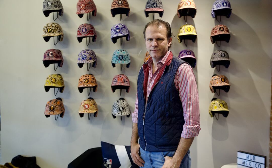 Rodrigo Fernández con los cascos de Grandes Ligas decorados con arte huichol - FOTO: Germán Espinosa / El Universal