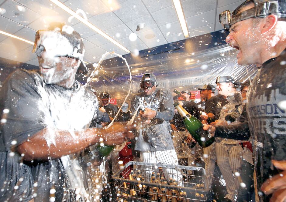 El pitcher abridor de Yankees, Luis Severino (centro) festejó con sus compañeros en los vestidores tras derrotar a los Red Sox y garantizar Playoffs (KATHY WILLENS. AP)