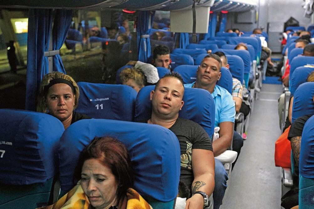 Cubanos en tránsito hacia Estados Unidos, que estaban varados en Costa Rica, pasaron ayer en autobús por la frontera entre Guatemala y El Salvador (ÓSCAR RIVERA. EFE)