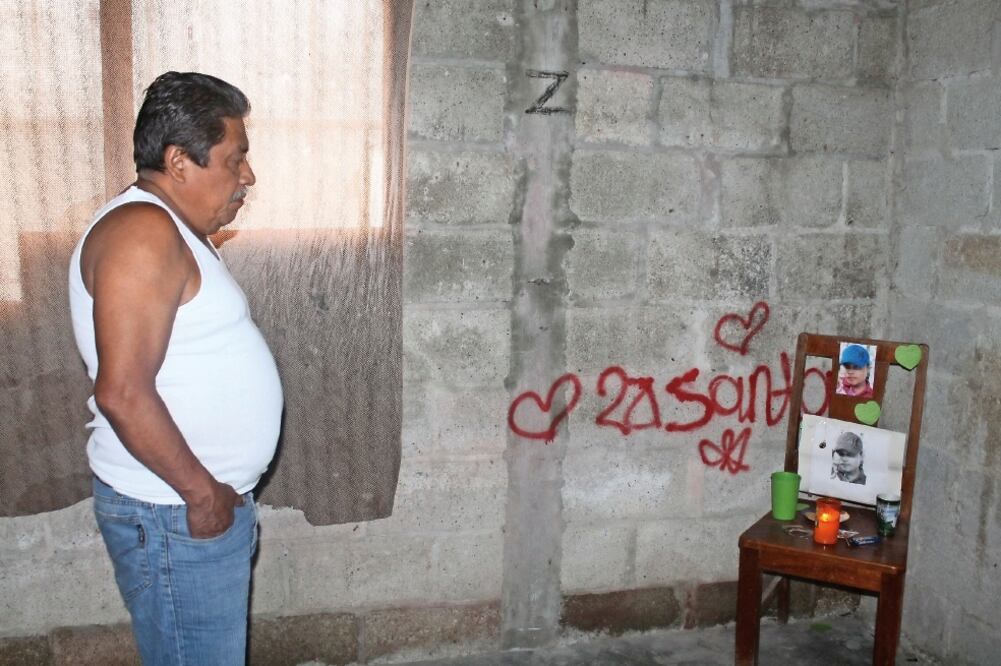 En el que era el cuarto de Alberto Uriel, que contiene pintas como una letra Z y no está amueblado, su padre observa con tristeza la foto de su hijo a la espera de que la justicia llegue (JOAQUIN GUERRERO. EL UNIVERSAL)