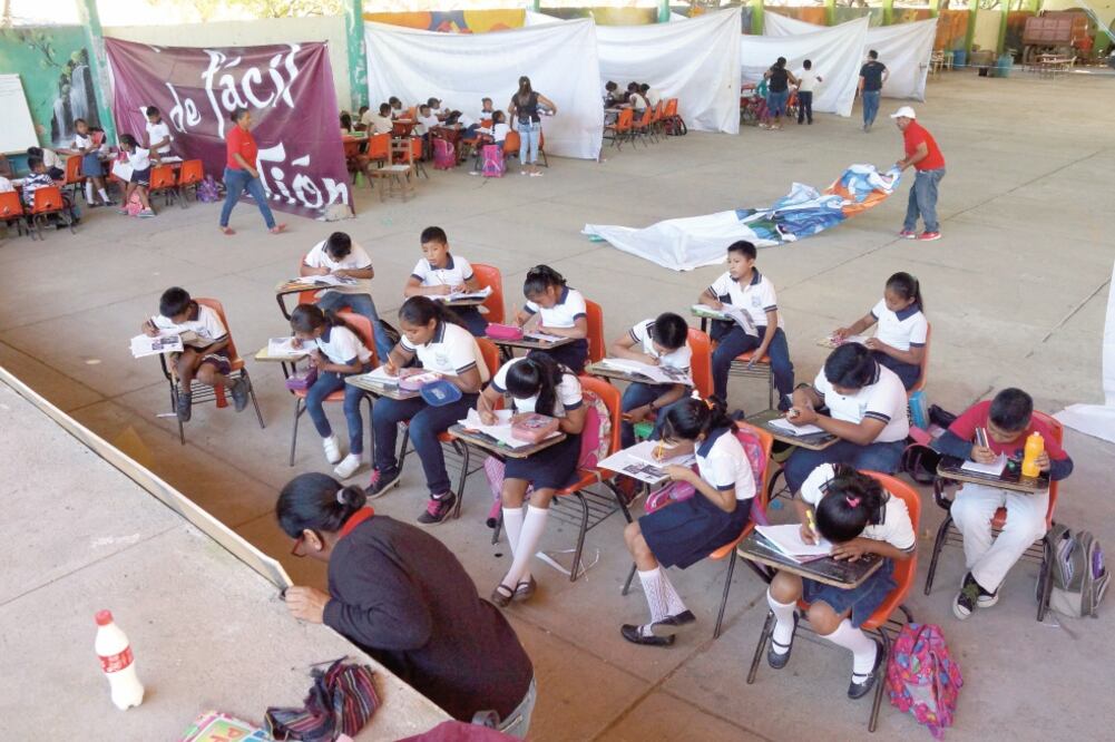 En los salones improvisados en el auditorio municipal los alumnos utilizan las sillas que lograron rescatar de su primaria. (EDWIN HERNÁNDEZ. EL UNIVERSAL)